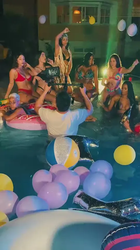 Rodaje de un videoclip en una piscina con globos, cámara en mano