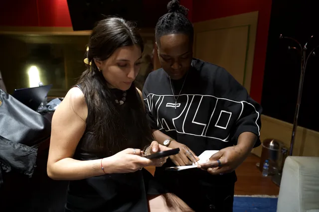 Dos artistas del DAP repasan una letra en el móvil durante la Mastermind