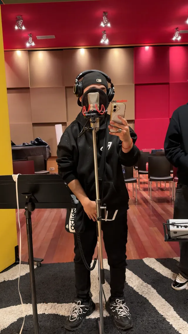 Un artista del DAP graba voces con cascos en la sala de PKO Studios