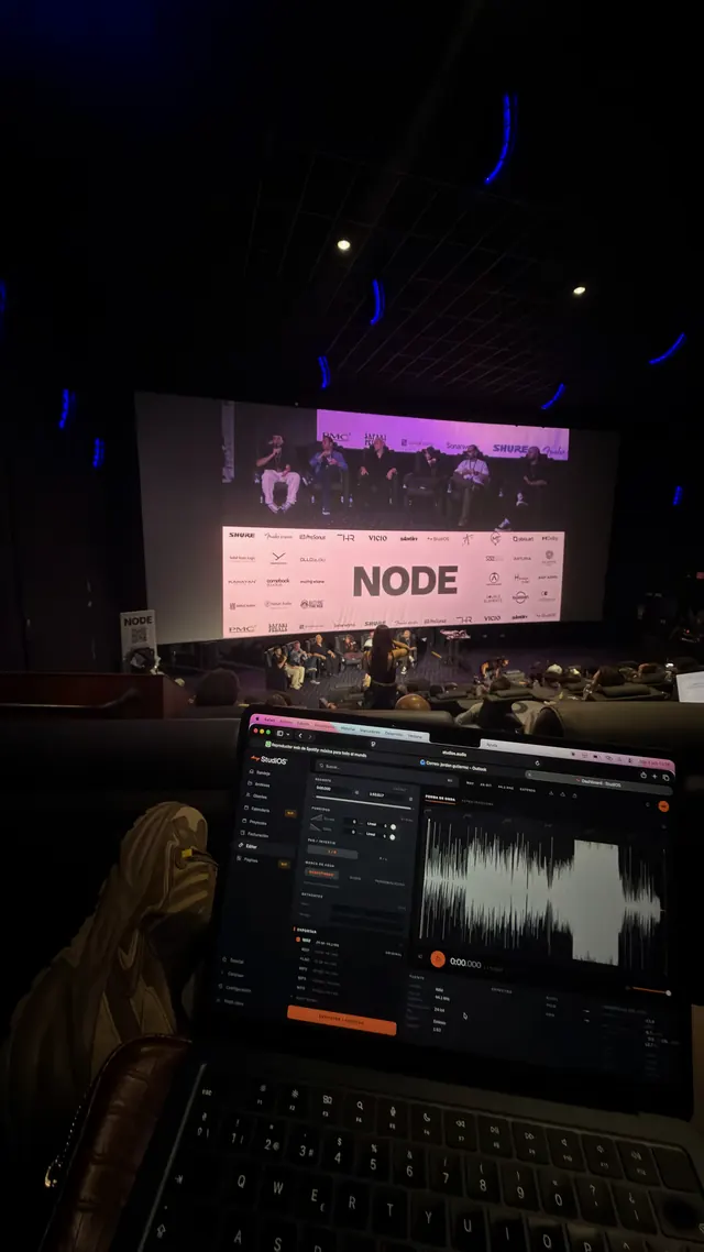 Una mesa de ponentes en el escenario de NODE 2026, vista desde la sala con un portátil abierto en primer plano