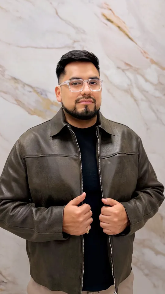Angelo Gutiérrez, «Macuto», fundador de Macuto Music, con chaqueta de cuero ante una pared de mármol