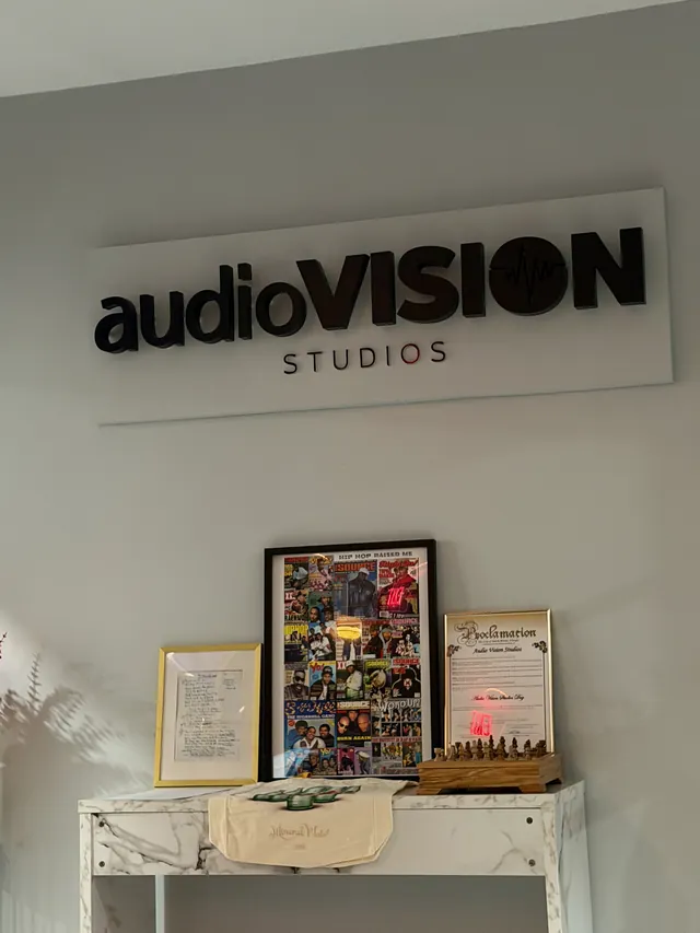 Rótulo de audioVision Studios en la recepción del estudio, con discos y diplomas enmarcados