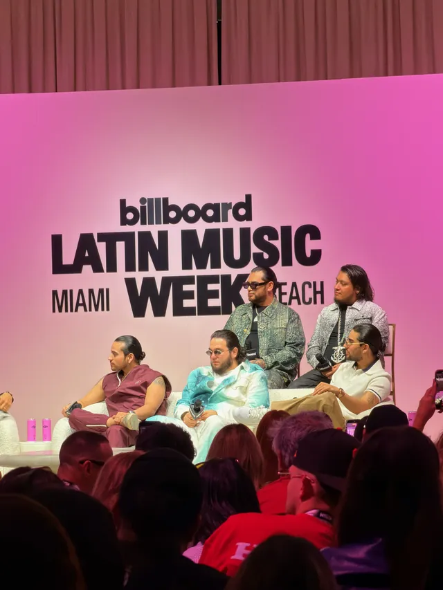 Panel en el escenario rosa de Billboard Latin Music Week, con el público en primer plano