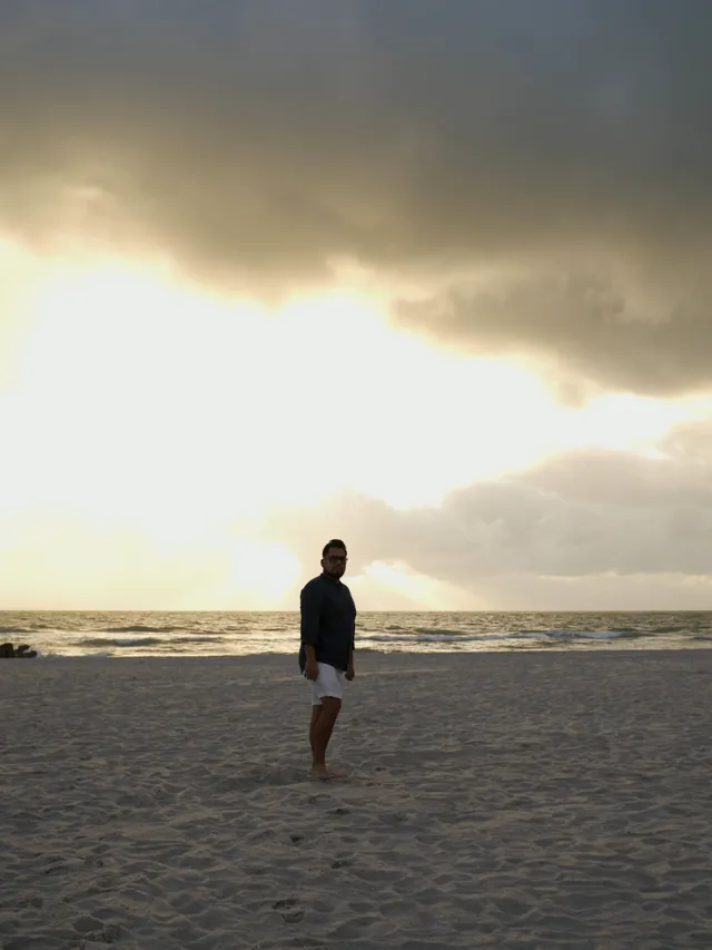 Macuto camina hacia la cámara por la playa de Miami Beach al amanecer