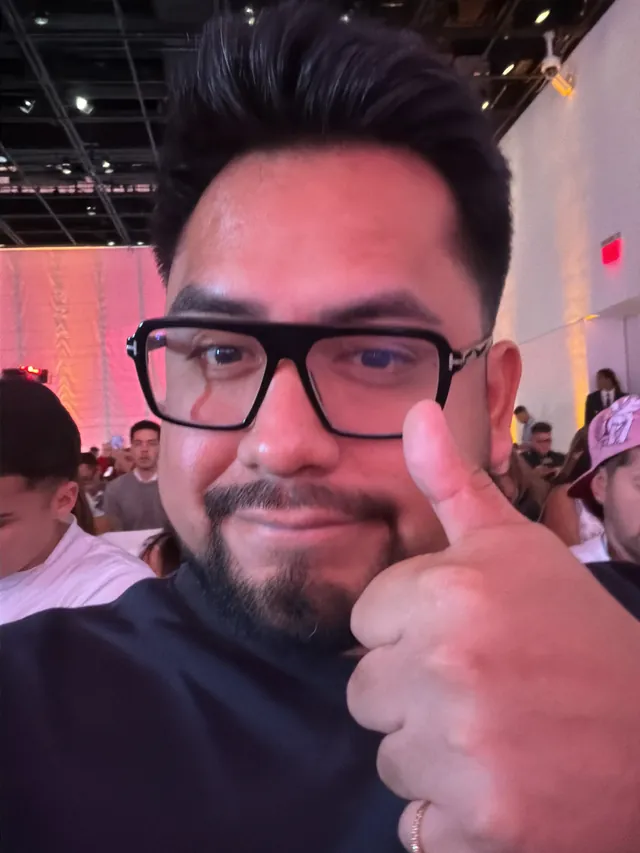 Selfi de Macuto con el pulgar hacia arriba entre el público de una conferencia