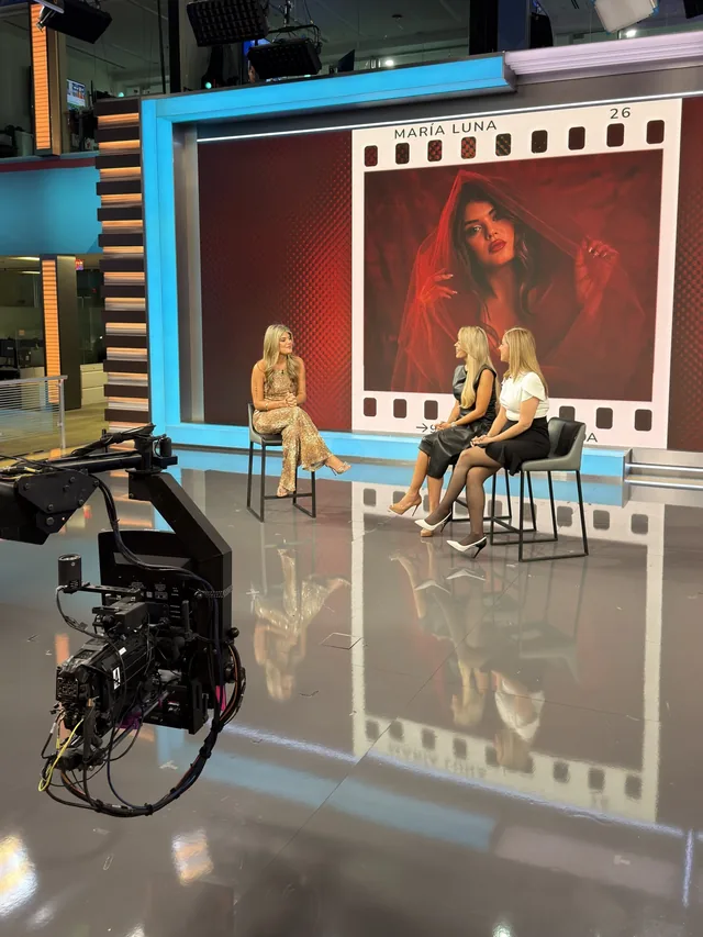 El plató de La Voz de la Mañana con una cámara en primer plano y María Luna sentada con las presentadoras